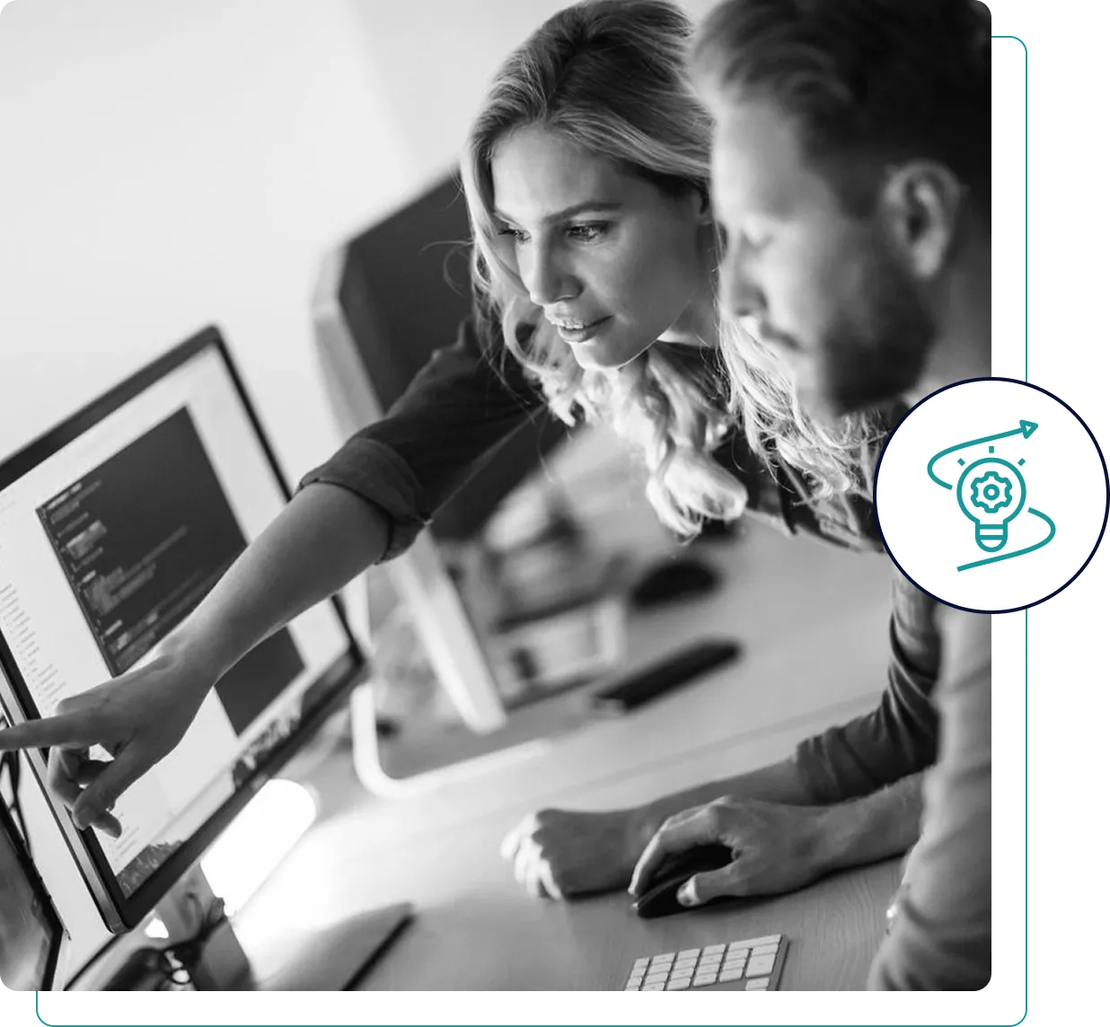 Two colleagues collaborating on a computer project in an office.