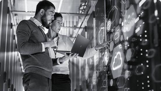 Two professionals discussing data visualizations on a transparent screen.