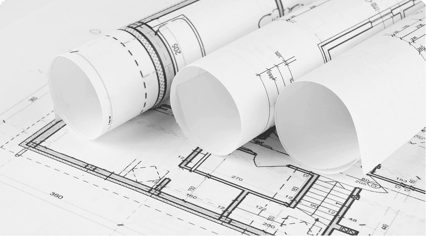 Rolled architectural blueprints on a detailed floor plan.